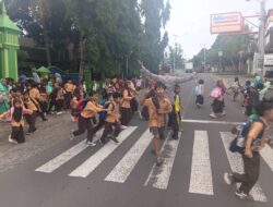 Personel Polsek Suela Atur Lalu Lintas di Depan SDN 02 Suela, Bantu Pelajar Menyeberang