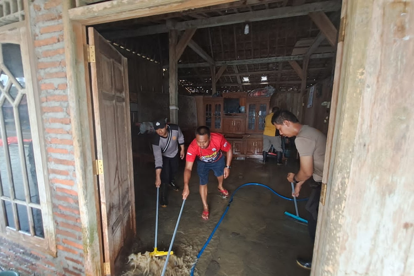 Bersama Warga, Polsek Tegowanu Bersihkan Lumpur Banjir